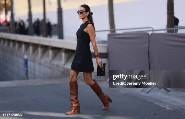 Tamara was seen wearing brown heels, Louis Vuitton petite malle bag, dark shades, a silver watch and a black dress with yelllow gold ornaments on her...