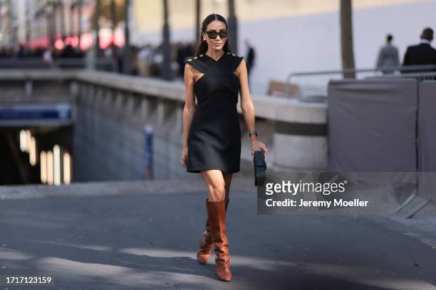 Tamara was seen wearing brown heels, Louis Vuitton petite malle bag, dark shades, a silver watch and a black dress with yelllow gold ornaments on her...