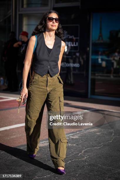 Caroline Issa wears a black vest, olive green cargo pants, outside Sacai, during the Womenswear Spring/Summer 2024 as part of Paris Fashion Week on...