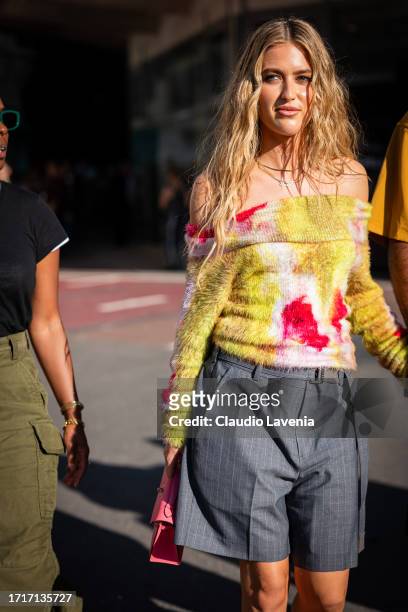 Emili Sindlev wears a yellow and pink sweater, grey striped shorts and pink bag, outside Sacai, during the Womenswear Spring/Summer 2024 as part of...
