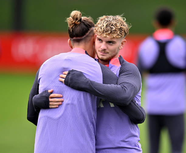 Harvey Elliott embracing Kostas Tsimikas of Liverpool during a training session at AXA Training Centre on October 04, 2023 in Kirkby, England.