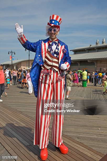 stiltwalker waving dressed as uncle sam - stilt walkers stock pictures, royalty-free photos & images