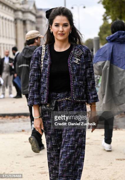 Guest is seen wearing a blue and purple tweed Chanel jacket and pants with a black bow outside the Chanel show during the Womenswear Spring/Summer...