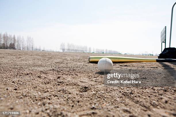 a baseball and a bat on the ground - 野球場　日本 ストックフォトと画像
