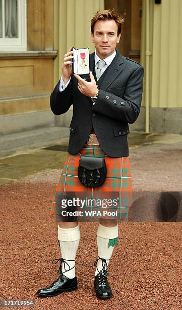 Actor Ewan McGregor holds his OBE after he received the award from Prince Charles, Prince of Wales during an Investiture ceremony at Buckingham...