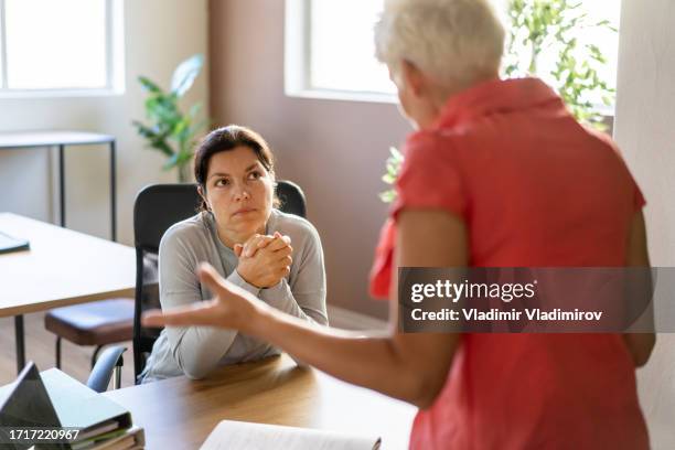 a female manager is talking with her employee in her office - scolding stock pictures, royalty-free photos & images