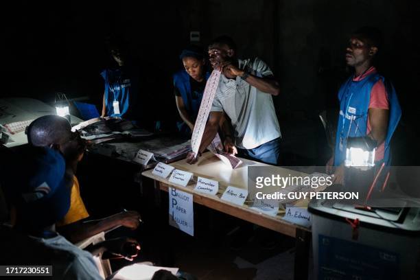 Election officials count the ballots of the general elections at a polling station in Monrovia on October 10, 2023. Liberians voted on whether to...