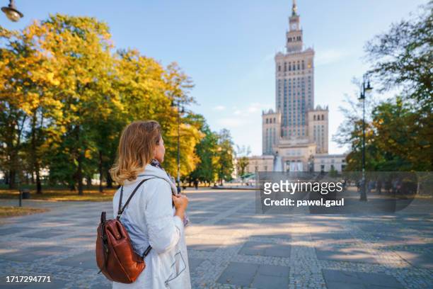 ポーランド、ワルシャワの文化科学宮殿を見る女性 - warsaw ストックフォトと画像