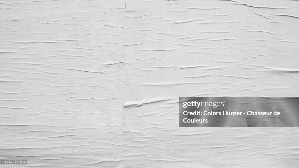 Close-up of white, empty, clean posters, pasted side by side and wrinkled in Paris, France