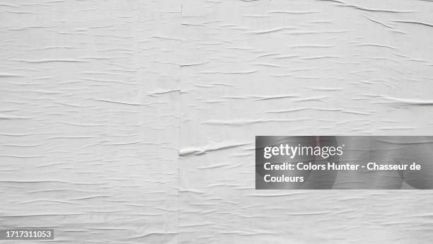 close-up of white, empty, clean posters, pasted side by side and wrinkled in paris, france - street poster stock pictures, royalty-free photos & images