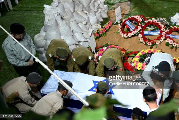 Israeli army soldiers carry the coffin with the remains of their comrade Noam Elimeleh Rothenberg during his funeral at Mount Herzl Cemetery in...