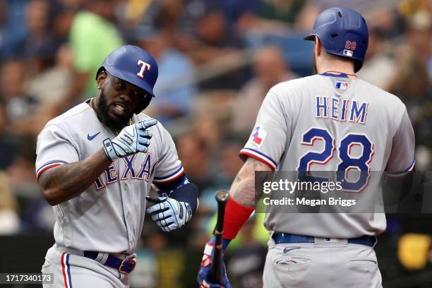 Adolis Garcia celebrates with Jonah Heim of the Texas Rangers after hitting a solo home run in the fourth inning against the Tampa Bay Rays during...