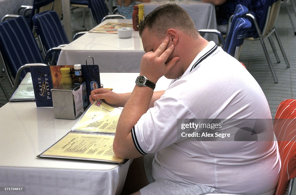 Obese young man at restaurant table