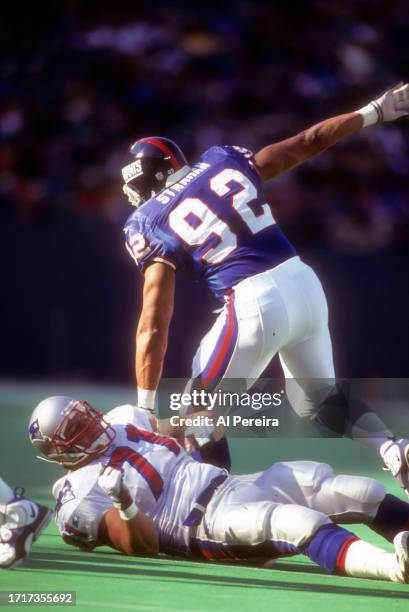 Defensive End Michael Strahan of the New York Giants follows the action in the game between the New England Patriots vs the New York Giants on...