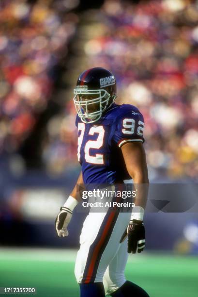 Defensive End Michael Strahan of the New York Giants follows the action in the game between the New England Patriots vs the New York Giants on...