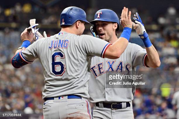 Evan Carter celebrates with Josh Jung of the Texas Rangers after hitting a two-run home run in the fourth inning against the Tampa Bay Rays during...