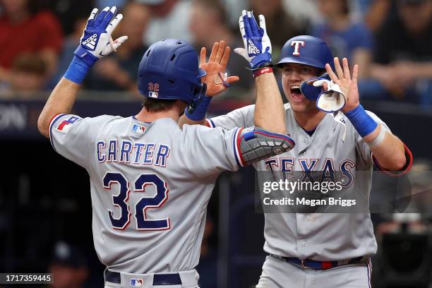 Evan Carter celebrates with Josh Jung of the Texas Rangers after hitting a two-run home run in the fourth inning against the Tampa Bay Rays during...