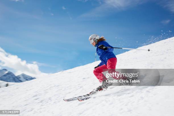 young woman skiing down mountain - schifahren stock-fotos und bilder