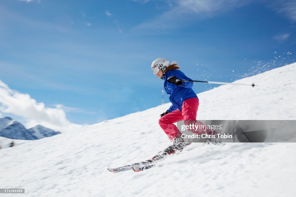 Young woman skiing down mountain