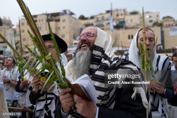 An Ultra-Orthodox Jew holds the lulav and etrog, part of the four important symbols, as he recites morning prayers before the Priestly Blessings, or...