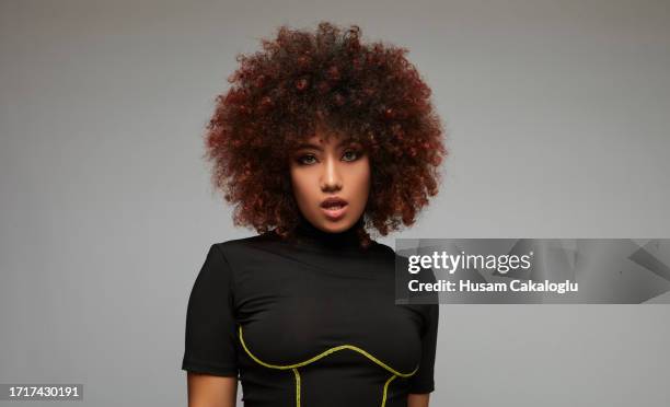 portrait of a mixed race young woman with curly and puffy hair. - beehive hair stock pictures, royalty-free photos & images
