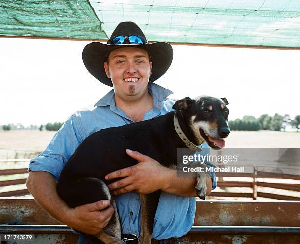 young farmer holding farm dog - farm australia combine fotografías e imágenes de stock