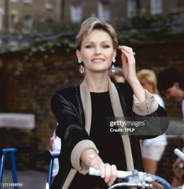 Portrait of British actress Fiona Fullerton as she poses on a multi-seat tandem bicycle, London, England, June 14, 1985.