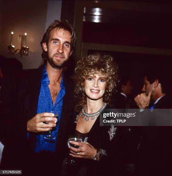 Portrait of British Rock musician Mike Rutherford, of the group Genesis, as he poses with an unidentified woman at an unspecified event, London,...