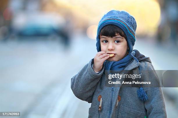 boy eating biscuit - knit hat stock pictures, royalty-free photos & images