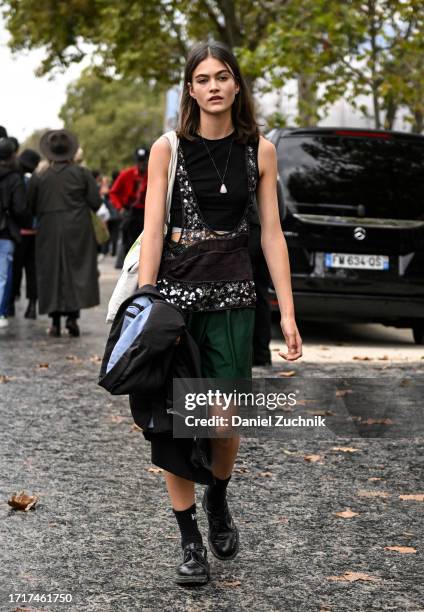 Model is seen wearing a black top, green shorts, black jacket and black shoes outside the Chanel show during the Womenswear Spring/Summer 2024 as...