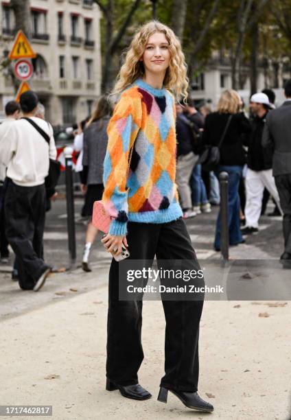 Model is seen wearing a blue and orange sweater and black jeans outside the Chanel show during the Womenswear Spring/Summer 2024 as part of Paris...