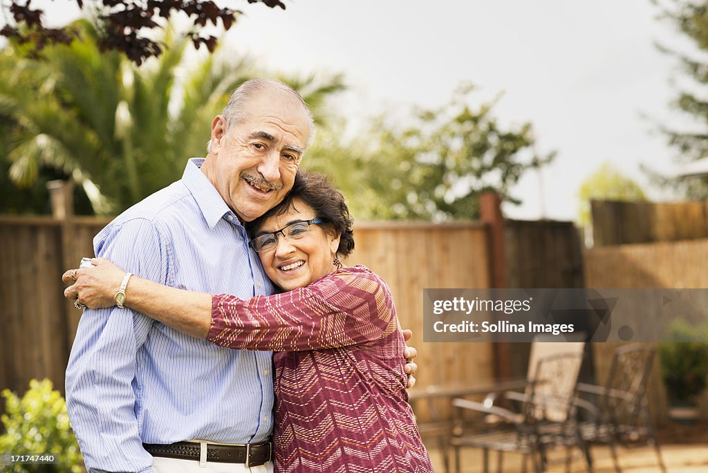Elderly couple smiling and hugging