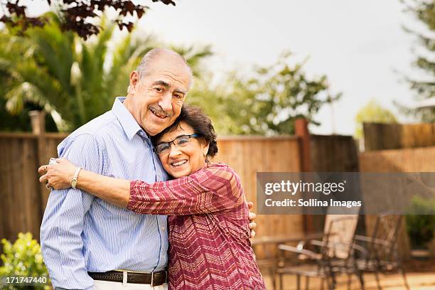 elderly couple smiling and hugging - hispanic couple stock pictures, royalty-free photos & images