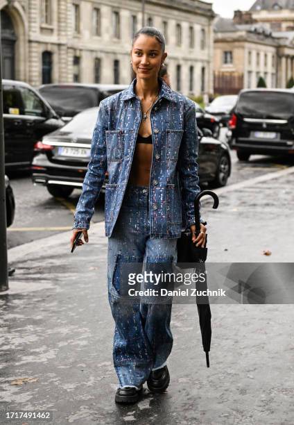 Model is seen wearing a blue paint splattered denim jacket and pants outside the Chanel show during the Womenswear Spring/Summer 2024 as part of...