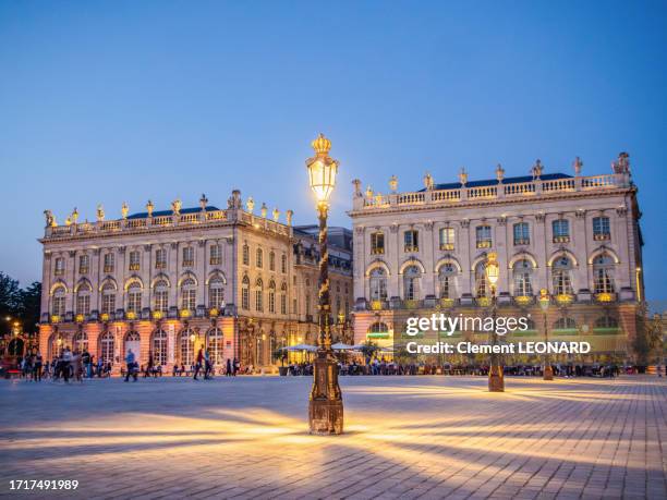 floor lamps lighting of the place stanislas (stanislaw square) at night in summer with people enjoying the pavement cafes in the background, nancy, meurthe et moselle, lorraine, eastern france. - meurthe et moselle stock pictures, royalty-free photos & images