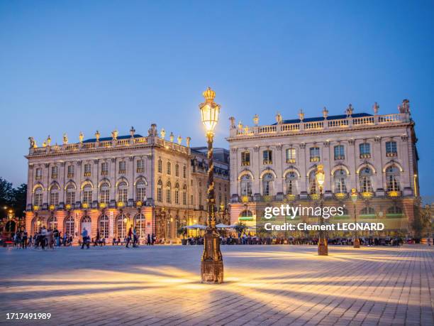 floor lamps lighting of the place stanislas (stanislaw square) at night in summer with people enjoying the pavement cafes in the background, nancy, meurthe et moselle, lorraine, eastern france. - stanislas stock pictures, royalty-free photos & images