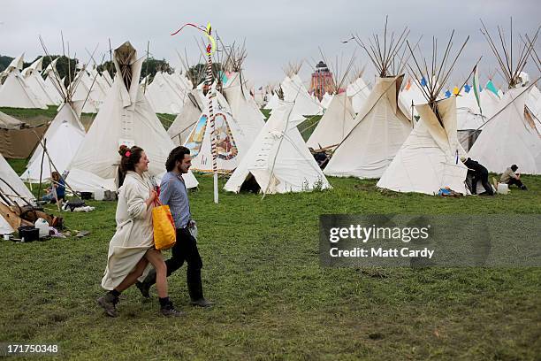 People walk through the tipi field at the Glastonbury Festival of Contemporary Performing Arts site at Worthy Farm, Pilton on June 28, 2013 near...