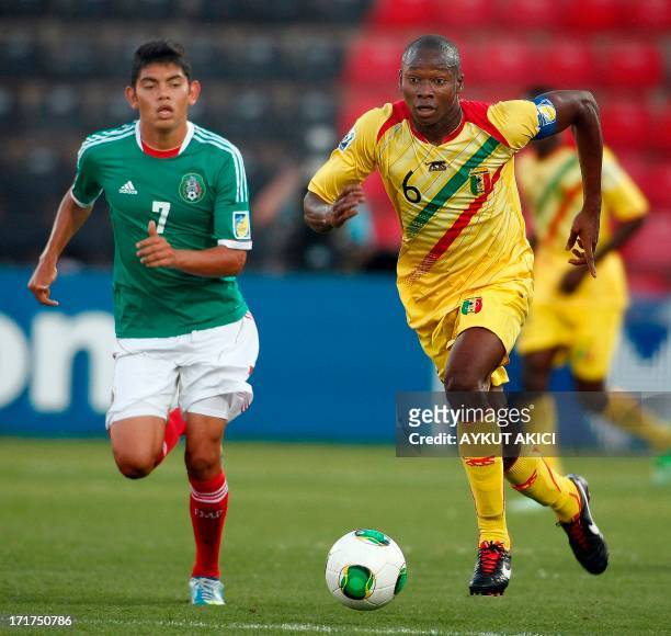 Mali's Boubacar Diarra runs with the ball, followed by Mexico's Jorge Espericueta during a group stage football match between Mali and Mexico at the...