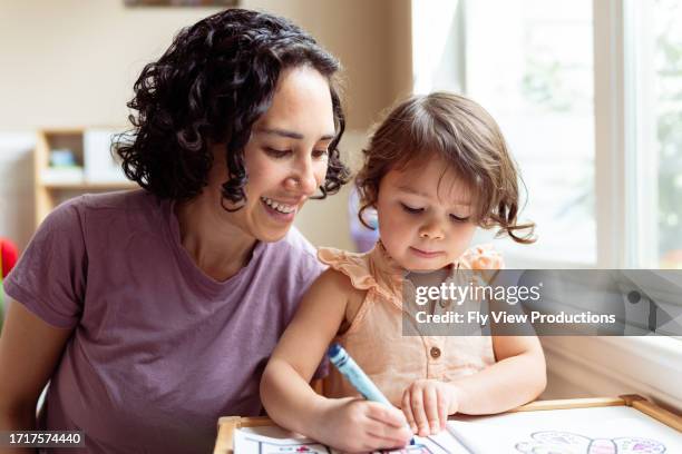 incoraggiare la figlia in età prescolare della mamma homeschooling - colorare foto e immagini stock