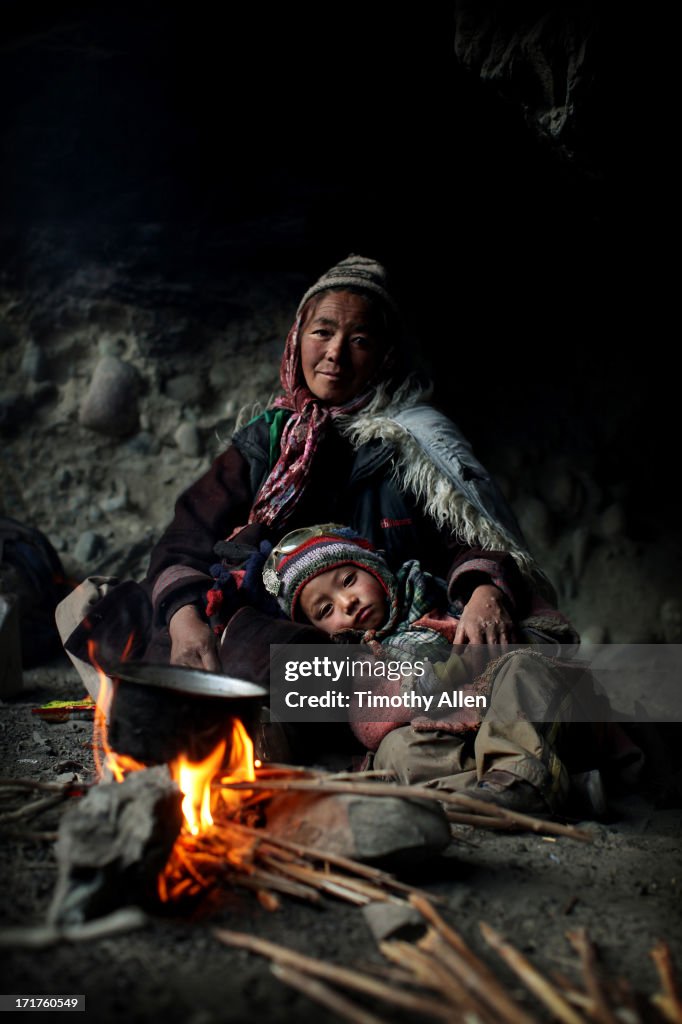 Mother and child by a fire in a cave
