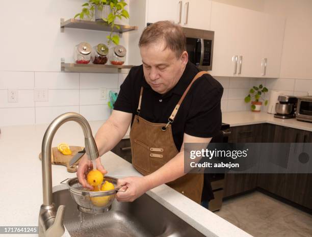 autistic man washing lemons - asperger syndrome stock pictures, royalty-free photos & images