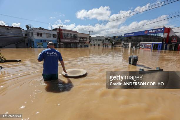 Adilson Ferreira da Silva driver, wades through the water to buy medicine for his newborn son, in the flooded Canoas neighbourhood in Rio do Sul,...