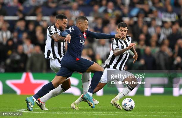 Newcastle players Jamaal Lascelles and Bruno Guimaraes close down Kylian Mbappe of PSG during the UEFA Champions League match between Newcastle...