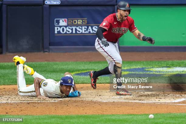 Tommy Pham of the Arizona Diamondbacks scores ahead of Abner Uribe of the Milwaukee Brewers during the sixth inning in Game Two of the Wild Card...