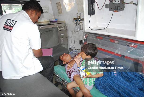 Woman with child rescued from Badrinath taken to the hospital at Doon Helidrome on June 28, 2013 in Dehradun, India. So far more than 1 lakh stranded...