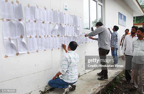 People searching names of their missing relative and friends on a list at Doon Helidrome on June 28, 2013 in Dehradun, India. So far more than 1 lakh...