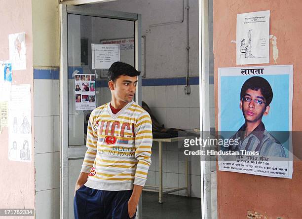 Man looked at a poster of a a boy missing from Kedarnath at Doon district hospital on June 28, 2013 in Dehradun, India. So far more than 1 lakh...