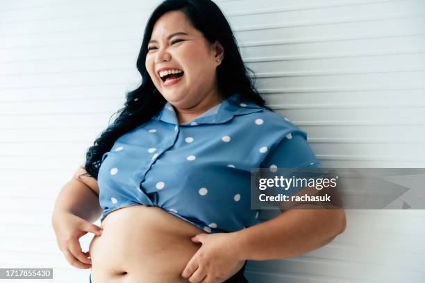 overweight female holding folds of skin on tummy - pinching stock pictures, royalty-free photos & images
