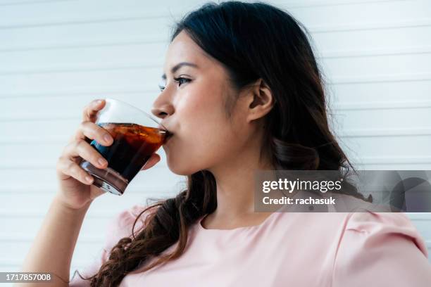 overweight woman drinking soft drink - frisdrank stockfoto's en -beelden