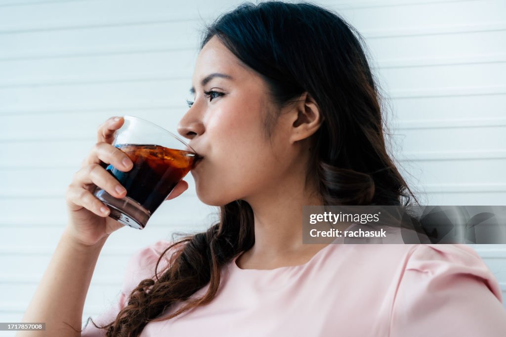 Overweight woman drinking soft drink
